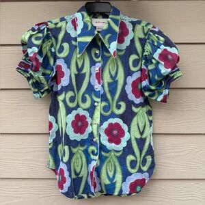 De Loreta blouse features a vibrant floral print and puff sleeves